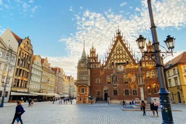 Breslauer Marktplatz mit Rathaus und bunten Häusern bei Sonnenschein.