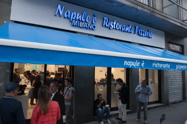 Davanti al ristorante pizzeria "Napule è" a Milano, gente fuori e dentro.