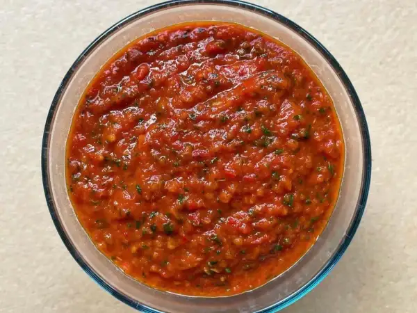 Bagnetto rosso piemontese in una ciotola di vetro, un condimento saporito e piccante, perfetto per accompagnare bolliti e carni.
