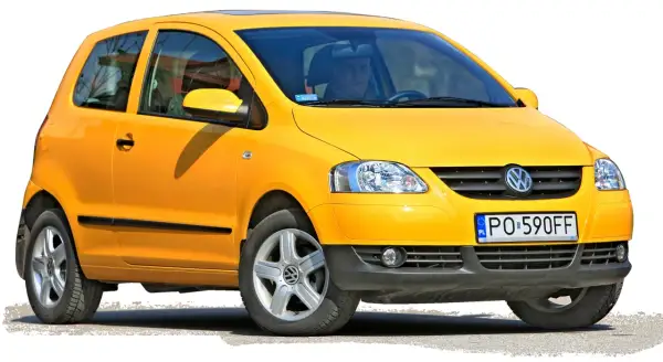 Żółty Volkswagen Fox z 2006 roku, z kierowcą za kierownicą, gotowy do jazdy.