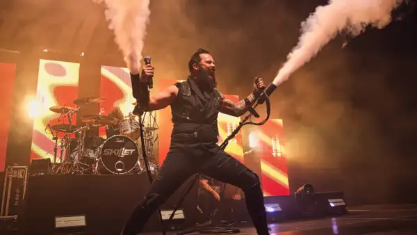 Skillet na koncercie w Warszawie, wokalista John Cooper strzela dymem z ręki.