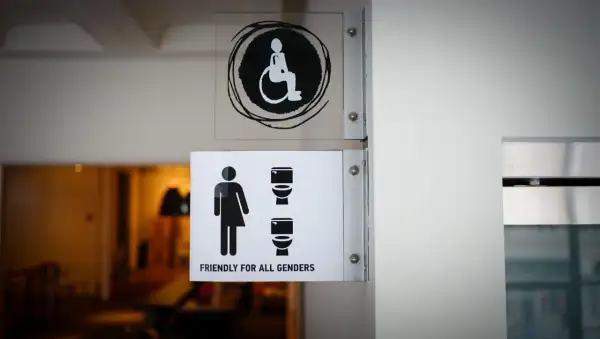 Znaki informujące o dostępności pomieszczeń higieniczno-sanitarnych, wymagania bhp. Widoczny symbol osoby na wózku inwalidzkim i toalety dla wszystkich płci.