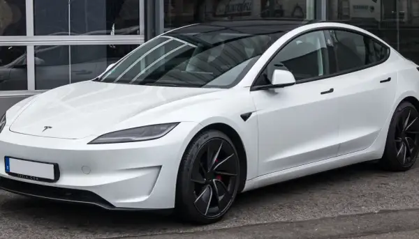 Tesla Model 3 blanco con techo negro. Su diseño aerodinámico sugiere una gran autonomía, optimizando la capacidad de la batería para viajes largos.