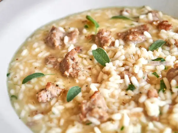 Cremiges Risotto mit herzhaften Salsiccia-Stücken und frischen Salbeiblättern.