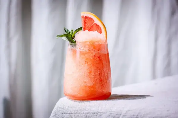 Erfrischender, gefrorener Aperol mit Grapefruitspalte und Minze. Perfekt für heiße Sommertage.