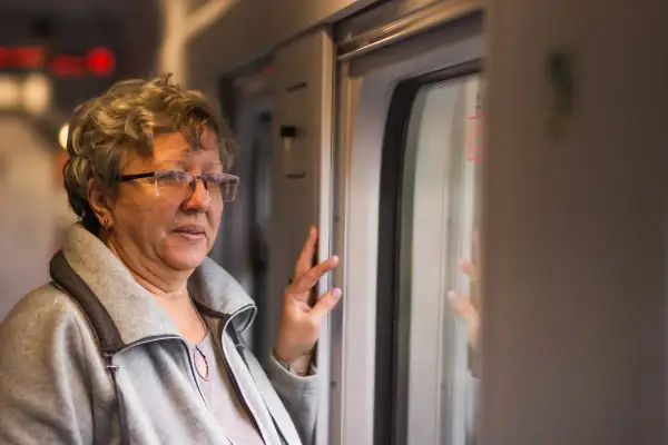 Starsza pani w okularach, podróżująca pociągiem, zastanawia się, ile znizki ma emeryt na PKP.