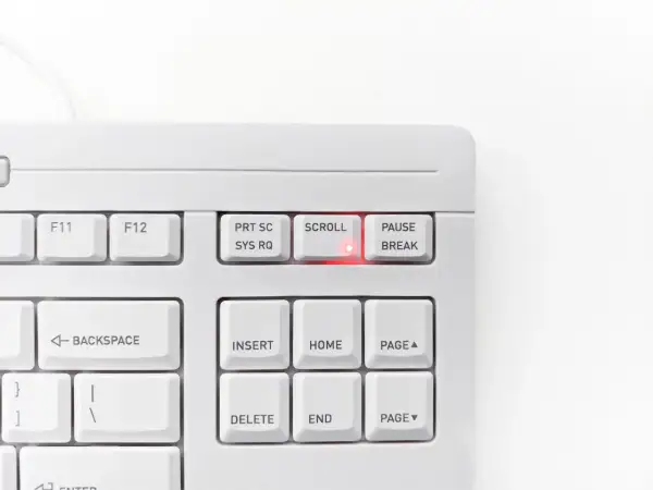 Biała klawiatura z podświetloną na czerwono diodą przy klawiszu SCROLL LOCK. Klawisz PAUSE/BREAK obok.