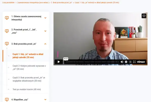 Mężczyzna w kratę tłumaczy, kiedy postawić przecinek przed "że", omawiając jego użycie w składzie jakiejś całości.