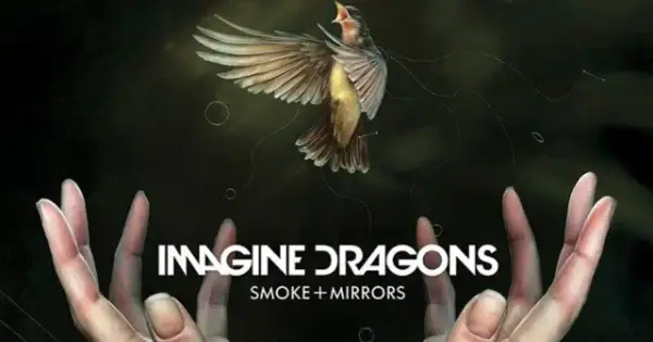 Ptak w locie nad dłońmi, z napisem "IMAGINE DRAGONS SMOKE + MIRRORS".