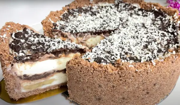 Pyszne ciasto w 5 minut bez pieczenia, z warstwami czekolady, kremu i bananów, posypane wiórkami.