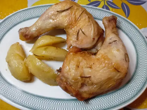 Cosce di pollo dorate e patate a spicchi, un piatto perfetto preparato nella friggitrice ad aria.