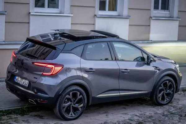 Szary Renault Captur z czarnym dachem i panoramicznym szyberdachem, idealny do miasta. Wiele pozytywnych renault captur opinie potwierdza jego wszechstronność.