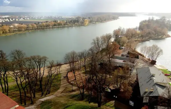 Malownicze jeziora kujawsko pomorskie z widokiem na miasto i wyspę porośniętą drzewami.