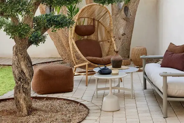 Gemütliche kleine Terrasse gestalten: Rattan-Sessel, Hocker, Sofa und Beistelltische laden zum Entspannen ein.