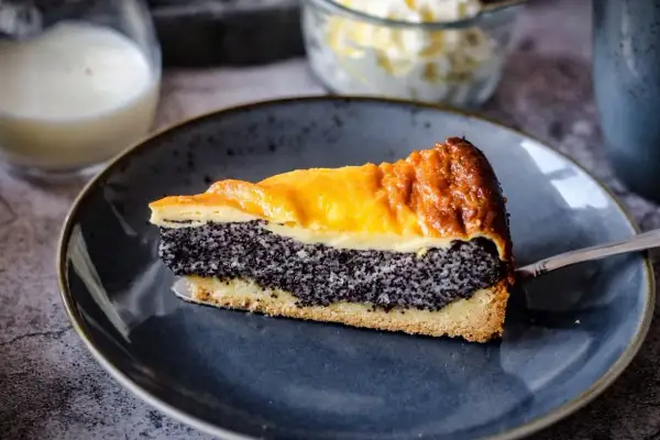 Ein Stück Mohn Schmand Kuchen mit goldbrauner Kruste und cremigem Mohn.