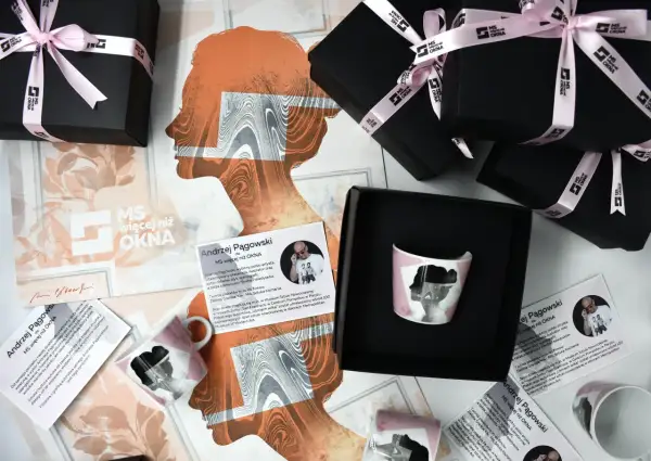 Kolekcja produktów z grafiką Andrzeja Pągowskiego, w tym kubek i pudełka, ozdobione są charakterystycznymi sylwetkami.