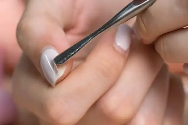 Manicure con attrezzo per cuticole, un passo fondamentale per imparare come fare le unghie in gel a casa e ottenere un risultato professionale.