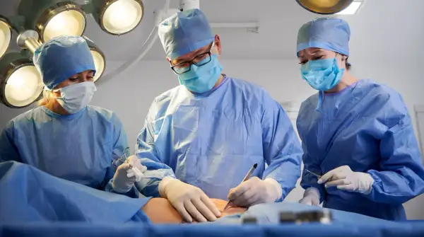 Chirurdzy w maseczkach i fartuchach operują. Czas jest kluczowy, gdy trzeba szybko operować raka.