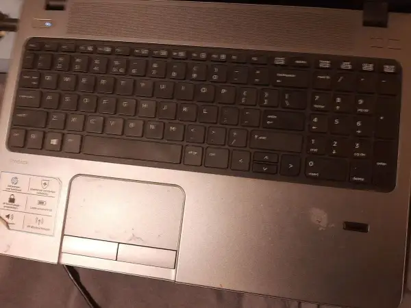 Klawiatura laptopa HP ProBook. Widoczny touchpad, klawisze numeryczne i literowe. Aby włączyć kursor w laptopie, użyj touchpada.