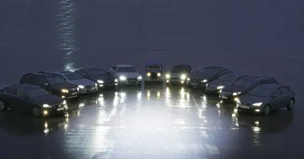 Różne rodzaje lamp samochodowych prezentowane na tle nocnego nieba. Od klasycznych reflektorów po nowoczesne LED-y, każdy pojazd oświetla drogę na swój sposób.