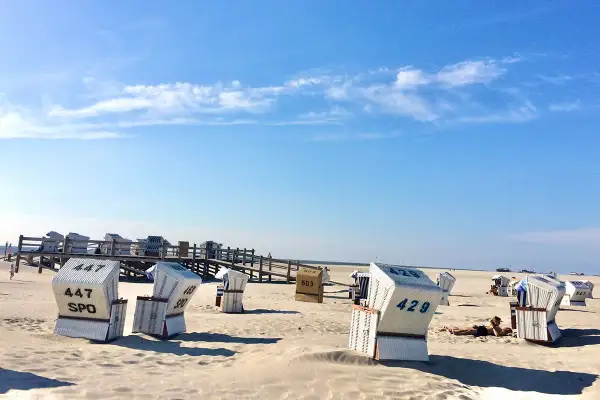 Strandkörbe am Strand von St. Peter-Ording, die Innenstadt ist nicht zu sehen, aber die typische Urlaubsatmosphäre ist spürbar.