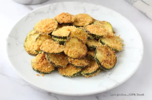 Fette di zucchine croccanti impanate, cotte nella friggitrice ad aria. Un contorno leggero e gustoso.
