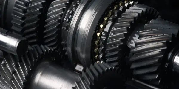 Zbliżenie na metalowe koła zębate i wałki, element skomplikowanej manualnej skrzyni biegów.