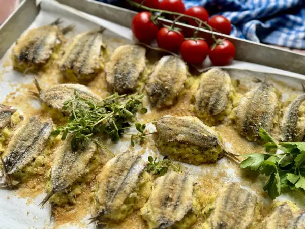 Acciughe ripiene alla ligure, dorate e croccanti, pronte per essere gustate. Un piatto che profuma di mare e tradizione.