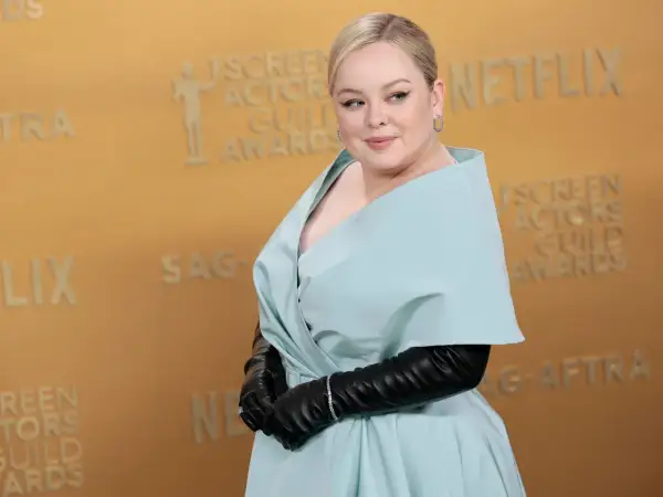 Nicola Coughlan, con su altura destacada, posa con un elegante vestido azul pálido y guantes negros en los Screen Actors Guild Awards.