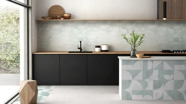 Cocina moderna con elegantes mosaicos de azulejos en paredes y barra. Tonos verdes y grises crean un ambiente fresco y sofisticado.