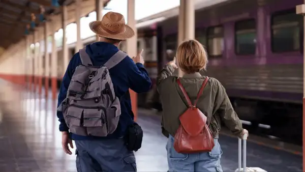 Para, plecak i walizka czekają na pociąg nad morze.