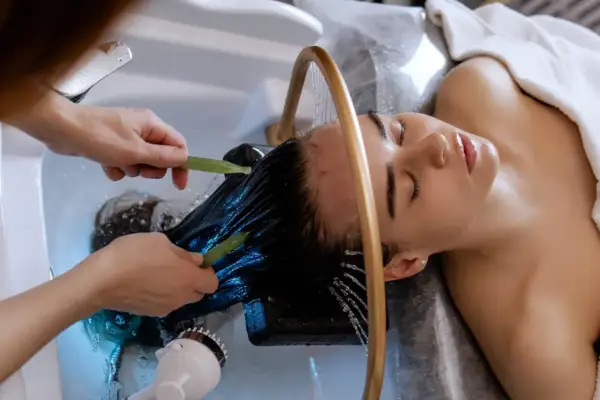 Relaks w trakcie zabiegu head spa. Delikatne masowanie skóry głowy i włosów wodą.