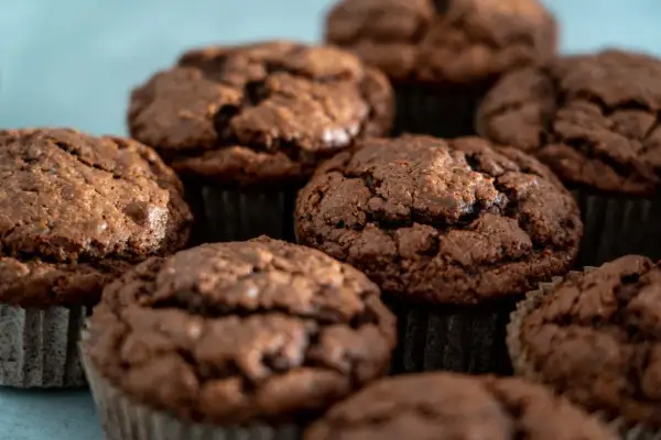 Kilka czekoladowych muffinek w papierowych papilotkach, zbliżenie.