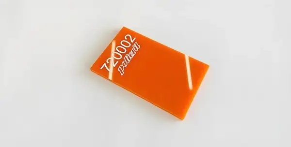 Un échantillon de plexi orange vif, portant le numéro 720002 et le mot "policril" en blanc.