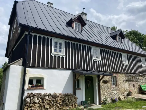 Jak sprawdzić czy budynek to zabytek? Ten dom z kamienia i drewna, z charakterystycznym dachem i oknami, może być cennym obiektem historycznym.