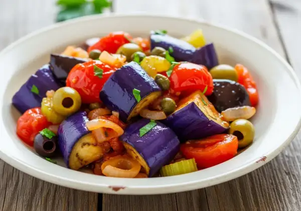 En härlig caponata med aubergine, tomater, oliver och kapris. Ett perfekt recept för en smakrik sallad.
