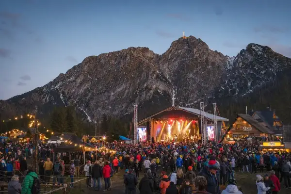 Tłumy ludzi na koncercie w Zakopanem pod oświetloną górą Giewont.
