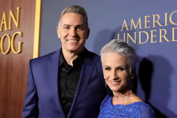 Brenda Warner und ihr Mann Kurt lächeln auf dem roten Teppich. Sie tragen elegante Kleidung.
