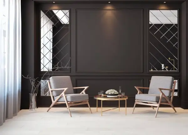 Eleganckie fotele i stolik kawowy na tle czarnej ściany z lustrzanymi panelami. Inspiracje do nowoczesnego salonu.