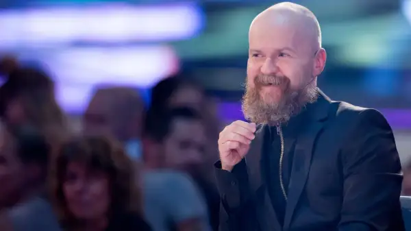 Alexander Bard, med sitt karaktäristiska skägg och skalliga huvud, ler och gestikulerar under ett event.