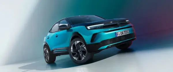 En turkos Opel Mokka med mörkt tak, som verkar ha ett litet problem med att stå rakt.