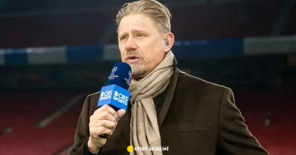 Antoni Schmeichel, z mikrofonem CBS Sports i szalikiem, komentuje mecz Ligi Mistrzów.