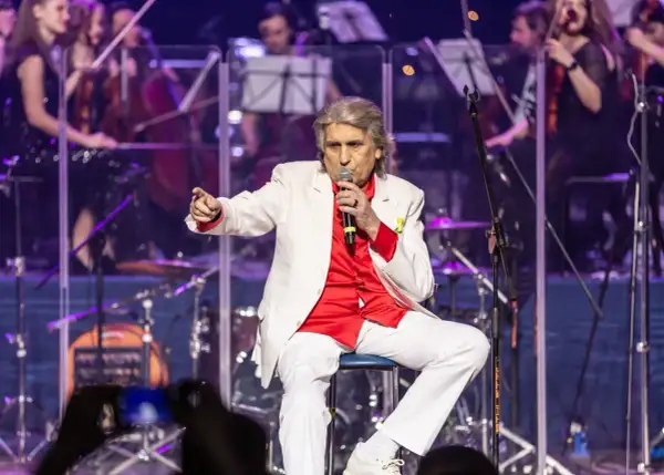 Toto Cutugno, w białej marynarce i czerwonej koszuli, śpiewa "L'Italiano".
