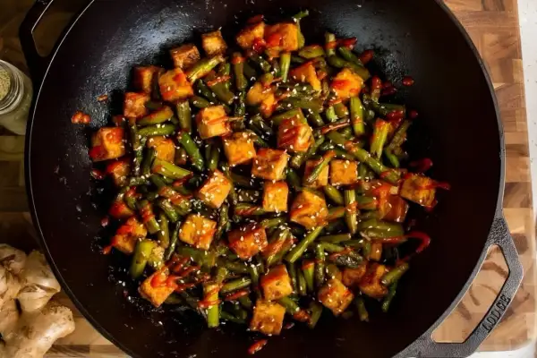 Salteado de verduras con tofu crujiente y sésamo en wok. Un plato vibrante y lleno de sabor.