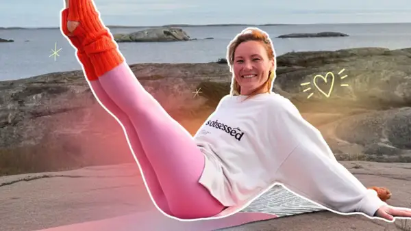 Kobieta w różowych legginsach i pomarańczowych ocieplaczach ćwiczy pilates na zewnątrz.