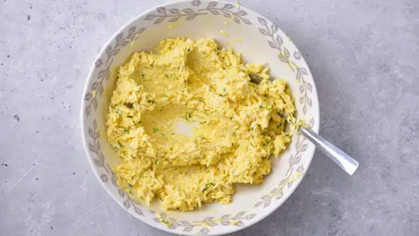 Mieszanka jajeczna z ziołami, przygotowana jako pasta jajeczna bez majonezu, w misce z ozdobnym brzegiem.
