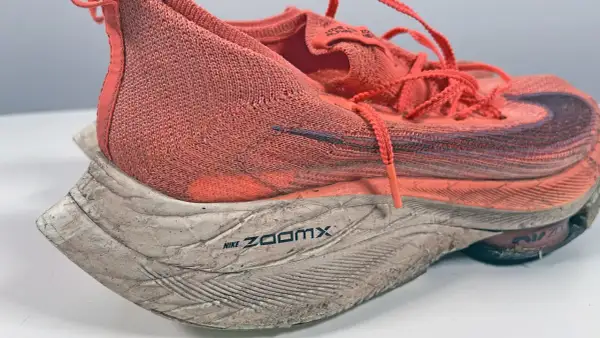 Scarpa da running Nike ZoomX arancione, usata ma ancora performante. La sua durata è testimoniata dai chilometri percorsi.