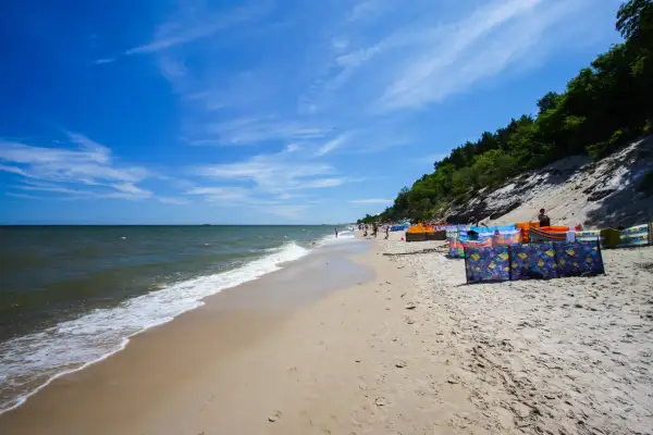 Słoneczna plaża w Chłapowie z kolorowymi parawanami, idealna na rodzinne wakacje. Atrakcje dla dzieci czekają!