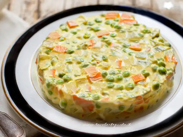 Insalata russa ricetta: un tortino cremoso di patate, carote, piselli e maionese, perfetto per ogni occasione.