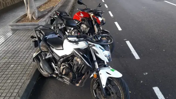 Dos motos Honda, una blanca y otra roja, aparcadas en la calle. ¿Listo para obtener tu carnet a como sacarlo?